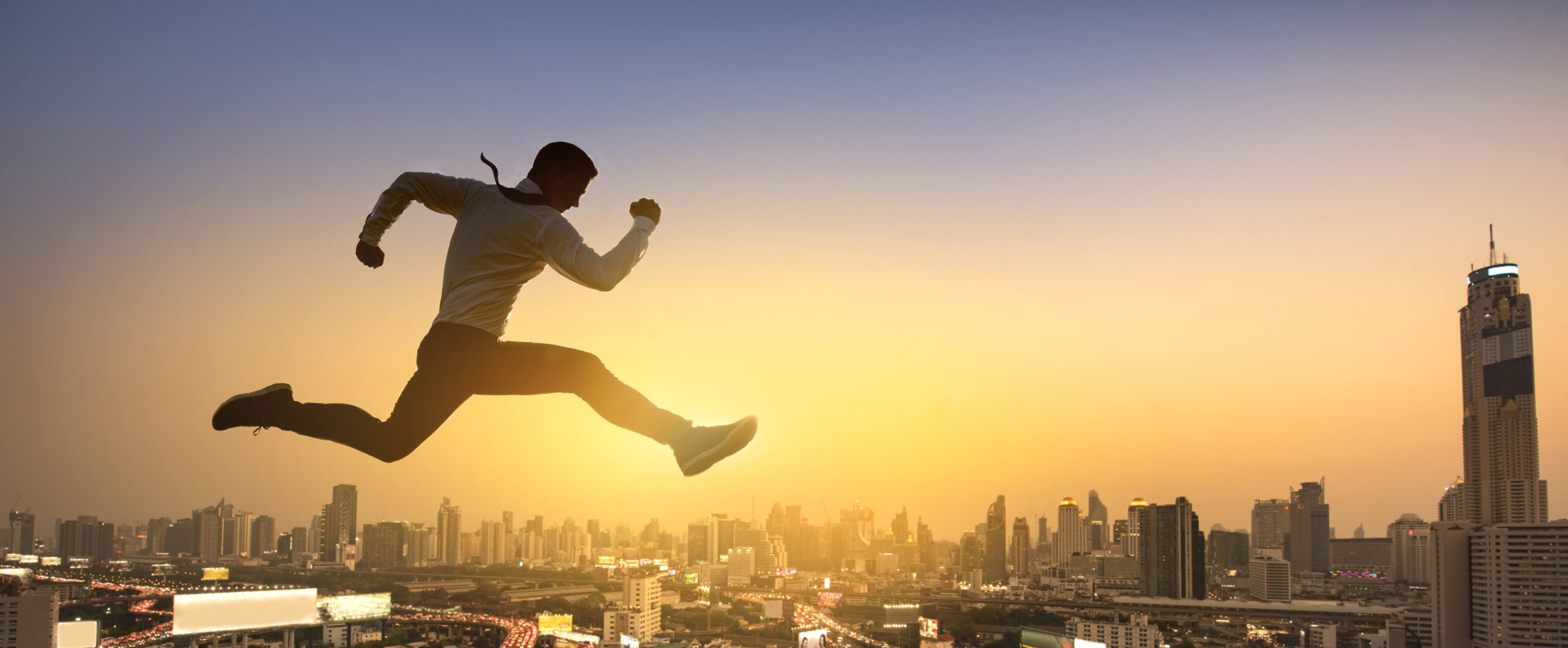 man jumping high with cityscape background