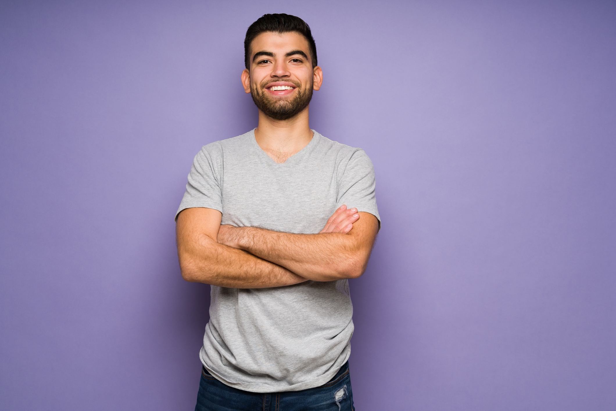 Attractive man looking cheerful on purple background